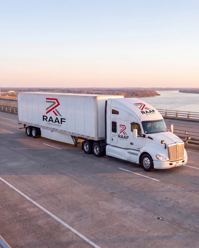 RAAF Logistics tractor with a 53-foot dry van crossing a bridge over a river